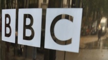 Ein Dateifoto zeigt das bekannte Logo der BBC auf den Glastüren eines ihrer Studios im Zentrum Londons. Foto: epa/Jerome Favre