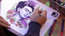 Besucherin koloriert ein Porträt von Frida Kahlo in einer immersiven Ausstellung in Bogotá, die Leben und Werk der mexikanischen Künstlerin erlebbar macht Foto: EPA/Carlos Ortega