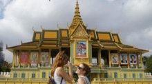 Touristen gehen an der Fassade des Königspalastes in Phnom Penh vorbei. Foto: EPA-EFE/Kith Serey
