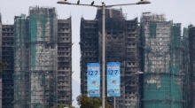 Ausgebrannte Gebäude in Tai Po stehen nahe einem Wahllokal, während Hongkong unter dem Eindruck eines tödlichen Wohnhausbrands das Parlament wählt. Archivfoto: epa/May James