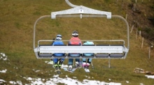 Skifahrer fahren mit einem Sessellift zwischen La Rasse und Chaux Ronde über ein schneefreies Feld auf 1600 Metern Höhe im alpinen Skigebiet von Villars-sur-Ollon. EPA-EFE/LAURENT GILLIERON