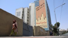 Eine Iranerin geht in Teheran an einem antiamerikanischen Wandbild vorbei. Trotz des Friedensabkommens kam es erneut zu Angriffen. Foto: Abedin Taherkenareh/epa