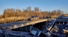 Ein Auto benutzt eine beschädigte Brücke in der Stadt Wowtschansk in der Region Charkiw. Foto: epa/Sergiy Kozlov