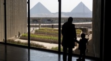 Frauen und Kinder betrachten die Pyramiden von Gizeh vom Großen Ägyptischen Museum aus gesehen. Foto: epa/Mohamed Hossam