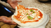 Francesco Ialazzo, Weltmeister der Pizzabäcker, bereitet im Café Planken eine Pizza Margherita vor. Foto: Uwe Anspach/dpa