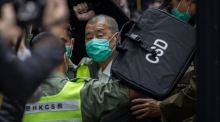 Medienunternehmer Jimmy Lai wird in Hongkong vor Gericht geführt; der Apple-Daily-Gründer erhielt 20 Jahre Haft im Sicherheitsprozess. Foto: epa/Jerome Favre