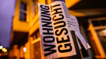 Ein Zettel mit der Aufschrift «Wohnung gesucht» hängt vor Wohnhäusern in Köln. Foto: Oliver Berg/dpa