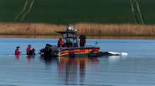 Helfer beobachten den festliegenden Buckelwal vor der Insel Poel. Seit Wochen bemüht sich eine Initiative um die Rettung im Flachwasser. Foto: Marcus Golejewski/dpa