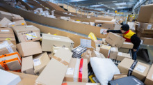 Ein Paketzusteller sortiert und räumt in einer Zustellbasis von Deutsche Post DHL Pakete in ein Zustellfahrzeug. Foto: Rolf Vennenbernd/dpa