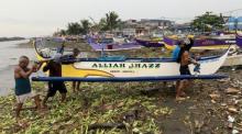 Fischer ziehen in einem Fischerdorf in der Stadt Cavite ein Boot an Land, bevor ein Taifun das Land erreichen wird. Foto: epa/Francis R. Malasig