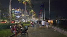 Touristen genießen einen Spaziergang entlang der Flusspromenade in Phnom Penh. Die Polizei betont die Bedeutung der Sicherheit für Besucher. Foto: Rüegsegger