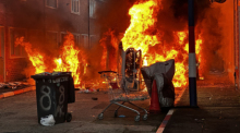Fahrzeuge, die von Demonstranten in der Lendrick Street in Belfast in Brand gesetzt wurden, während Unruhen nach einem Messerangriff am Montagabend in der Stadt aufflammten. Foto: Pa/Pa Wire/dpa