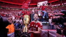 Harry Kane feiert mit dem DFB-Pokal vor den Fans nach Bayerns Finalsieg gegen Stuttgart in Berlin. Foto: epa/Ronald Wittek