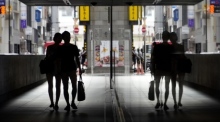 Ein Ehepaar wird in einem Spiegel reflektiert, während es durch eine Unterführung in Tokio geht. Foto: epa/Franck Robichon