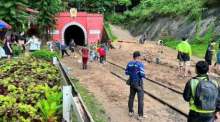 Bahnmitarbeiter räumen die nach einem Erdrutsch verschütteten Gleise am nördlichen Portal des Khun-Tan-Tunnels frei. Bild: State Railway of Thailand