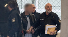 Polizisten führen den Mörder des 2005 ermordeten Münchener Modemachers Moshammer am Flughafen zu einem Abschiebeflug. Foto: Boris Roessler/dpa