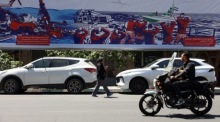 Passanten gehen in Teheran an einem antiamerikanischen Plakat nahe der ehemaligen US-Botschaft vorbei Foto: EPA/Abedin Taherkenareh