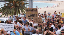 Mehrere Personen protestieren mit Plakaten während einer Demonstration gegen das Massentourismusmodell. Foto: Europa Press Canarias/Europa Press/dpa