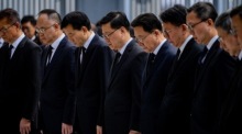 Hongkongs Regierungschef John Lee und Beamte halten eine Schweigeminute, während die Flaggen für die Opfer des Feuers in Tai Po auf Halbmast stehen. Foto: EPA/Leung Man Hei