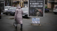 Eine Frau geht an einem Transparent mit der Aufschrift «Marineinfanteristen - Helden von Mariupol - vergesst nicht die, die noch in Gefangenschaft sind» vorbei. Foto: Daniel Cole/Ap/dpa