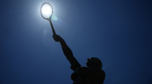 Die Sonne scheint über der Statue der französischen Tennislegende Jean Borotra während des French Open Tennisturniers. Foto: Christophe Ena/Ap/dpa