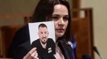 Swetlana Tichanowskaja zeigt 2021 im tschechischen Senat ein Bild ihres damals inhaftierten Mannes Sergej Tichanowski. Foto: epa/Roman Vondrous