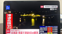 Ein Bildschirm zeigt Bebenwarnungen, nachdem ein Erdbeben den Nordosten Japans erschüttert und eine Tsunamiwarnung ausgelöst hat. DaFoto: dpa/Li Ziyue