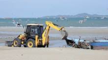 Ein Bagger beginnt am Strand von Nord-Pattaya mit der Zerlegung des bei einem Sturm gesunkenen Boots. Bild: TMN.TV