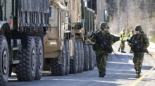 Die schwedischen Soldaten gehen neben einer Kolonne von Fahrzeugen des U.S. Marine Corps. Foto: epa/Pontus Lundahl Schweden Out