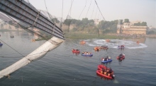 Polizisten und Militärangehörige der National Disaster Response Force (NDRF) arbeiten an der Stelle, an der eine 100 Jahre alte Hängebrücke in Morbi, Gujarat, zusammengebrochen ist. Foto: epa/Siddharaj Solanki