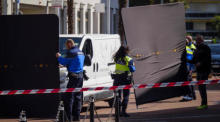 Bestattungsfahrzeuge treffen am Ort der Tragödie ein, bei der vier Menschen ums Leben kamen und ein Mensch nach einem Sturz aus seiner Wohnung in Montreux schwer verletzt wurde. Foto: epa/Jean-christophe Bott