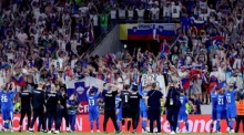 Slowenische Spieler feiern vor ihren Fans nach dem Fußballspiel der UEFA EURO 2024 Gruppe C zwischen England und Slowenien. Foto: epa-efe/Olivier Matthys