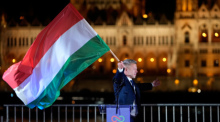 Peter Magyar, der Vorsitzende der Oppositionspartei Tisza, schwenkt nach der Parlamentswahl eine Nationalflagge. Foto: Darko Bandic/Ap/dpa