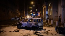 Ein beschädigtes Auto steht nach Zusammenstößen zwischen Demonstranten und der Polizei bei Protesten für den gestorbenen Marokkaner Abderrahim Fakir in Bologna. Foto: EPA/Max Cavallari