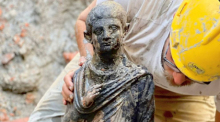 Dieses undatierte vom italienischen Kulturministerium zur Verfügung gestellte Foto zeigt einen Archäologen, der an einer Statue, die am Fundort von zwei Dutzend gut erhaltenen Bronzestatuen aus ... Foto: Uncredited/Italian Culture Ministry Via Ap