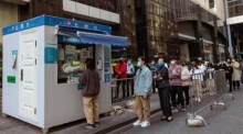 Menschen stehen in einer Schlange für einen Coronavirus-PCR-Test an einem Teststand auf der Straße in Shanghai. Foto: epa/Alex Plavevski