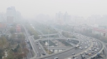 Autos fahren auf einer Straße, während starker Smog über der Stadt hängt. Die Feinstaubbelastung ist für Menschen weltweit nach wie vor sehr groß. Foto: Song Jiaru/Sipa Asia/sipa Asia Via Zuma Press Wire/dpa