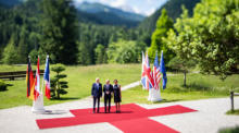 Bundeskanzler Olaf Scholz (C) und seine Frau Britta Ernst (R) begrüßen US-Präsident Joe Biden (L) auf Schloss Elmau in Krün. Foto: epa/Christian Bruna