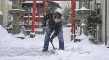 Ein Mann schaufelt Schnee vor einem Schrein. Schnee und Kälte haben weite Teile Japans heimgesucht und den Straßen-, Flug- und Zugverkehr behindert. Es wurden weitere Schneefälle und kalte Temperaturen vorher... Foto: Uncredited/Kyodo News/ap/dpa