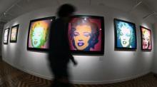 Besucher gehen an mehreren Porträts der US-Schauspielerin Marilyn Monroe vorbei. Foto: epa/Fernando Villar