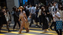 Personen tragen Gesichtsmasken, als sie eine Kreuzung in Central, Hongkong, überqueren. Foto: epa/Jerome Favre