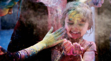 Ein Kind spielt mit farbigem Pulver während der Feierlichkeiten zum Holi Fest. Das Holi Fest markiert den Beginn des Frühlings und den Triumph des Guten über das Böse. Foto: Str/Xinhua/dpa