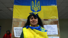Liana, eine Freiwillige, posiert mit der ukrainischen Flagge, während sie im logistischen Hauptquartier für die ukrainische Armee, den Zivilschutz und die Flüchtlingshilfe in der Region Dnipro arbeitet. Foto: epa/Nuno Veiga
