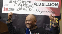 Cheng "Charlie" Saephan hält einen übergroßen Scheck über seinen Kopf, nachdem er auf einer Pressekonferenz in der Lotteriezentrale von Oregon in Salem. Foto: Jenny Kane/Ap/dpa
