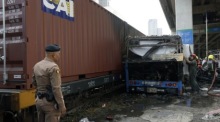 Rettungskräfte und Ermittler sichern nach der tödlichen Kollision zwischen einem Güterzug und einem Linienbus die Unfallstelle am Bahnübergang nahe der Makkasan-Airport-Rail-Link-Station in Bangkok. Foto: epa/Rungroj Yongrit