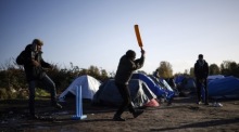 Die Migranten spielen Kricket in dem behelfsmäßigen Migrantenlager in Loon Plage. Foto: epa/Yoan Valat