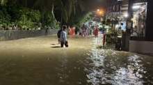 Bild 1: Bewohner waten in der Nacht durch überflutete Straßen, nachdem starke Regenfälle mehrere Gemeinden im Süden Thailands unter Wasser gesetzt hatten. Bild: DDPM
