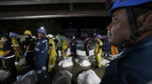 Rettungskräfte und Ermittler arbeiten am Unglücksort, nachdem das Feuer zahlreiche Todesopfer und Verletzte gefordert hatte. Foto: epa/Rungroj Yongrit