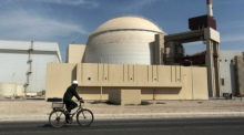 Ein Mann fährt mit dem Fahrrad an dem Reaktorgebäude des Kernkraftwerks Bushehr vorbei. Foto: Majid Asgaripour/Ap/dpa