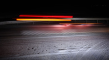 Ein Auto fährt am frühen Morgen auf schneeglatter Straße (Langzeitbelichtung). Foto: Karl-Josef Hildenbrand/dpa